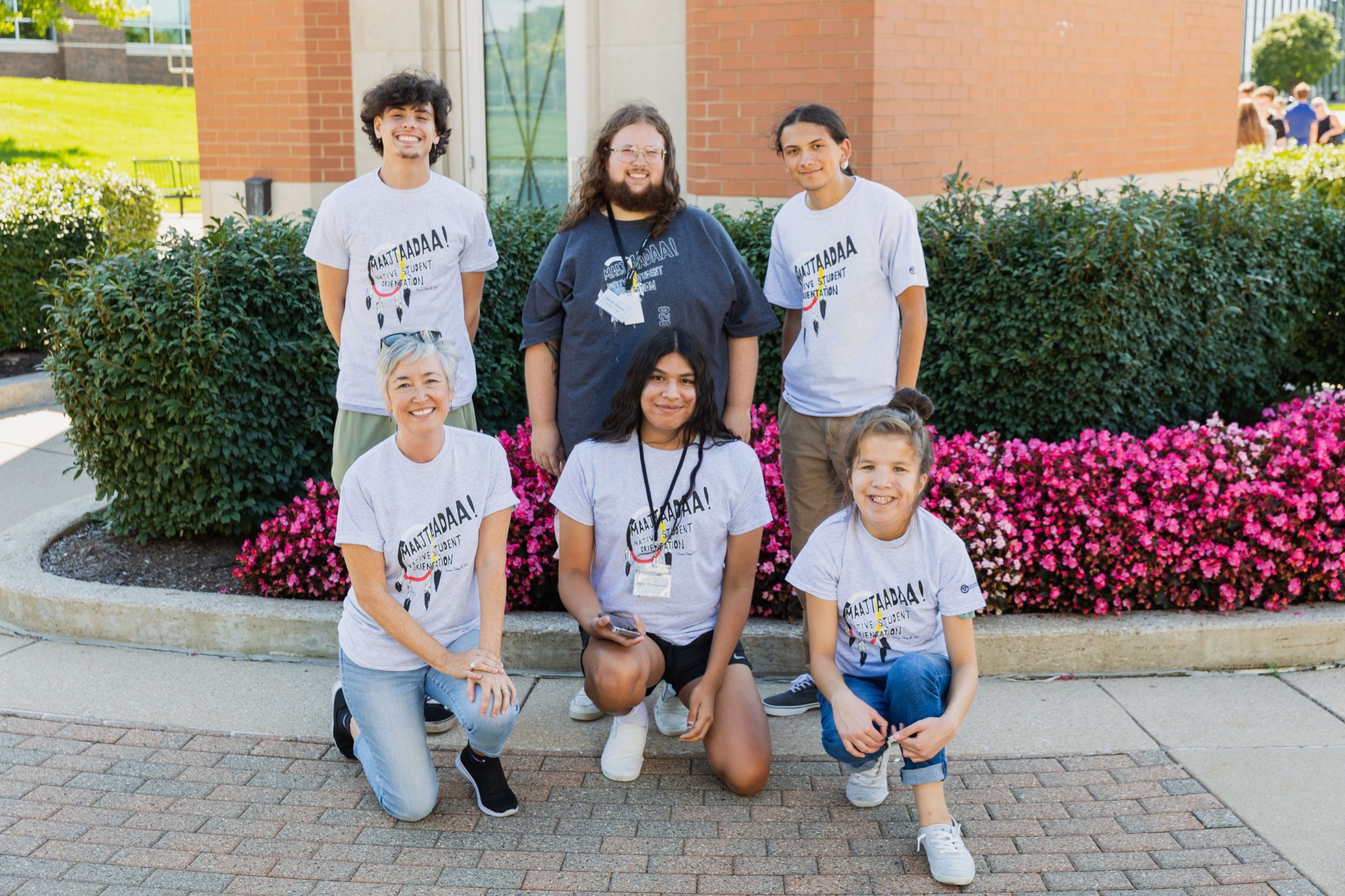 6 members during the orientation standing in front of a clocktower on GVSU campus